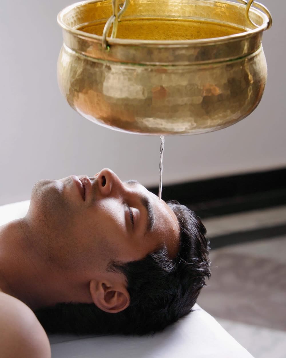 Shirodhara: brass vessel and warm stream